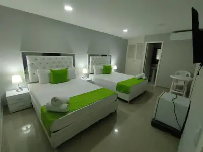 two beds in a bedroom with green and white at Bm-16 room near the sea with air conditioning and WIFI in Cartagena de Indias
