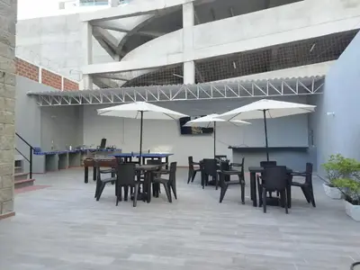 a patio with tables and chairs and umbrellas at Bm-16 room near the sea with air conditioning and WIFI in Cartagena de Indias