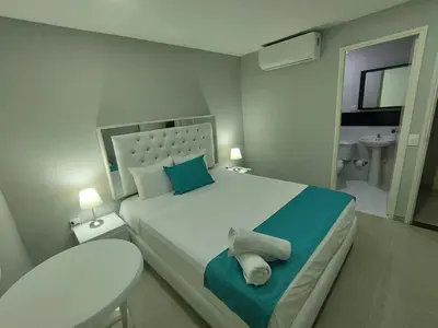 a bedroom with a large bed and a bathroom at Cozy room Bm-10 near the sea with air conditioning and WIFI in Cartagena de Indias