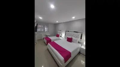 a bedroom with two beds with pink pillows at Bm-2 room near the sea with air conditioning and WIFI in Cartagena de Indias