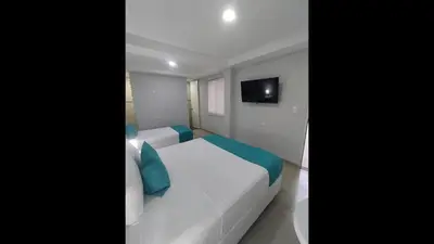 a bedroom with a white bed and a tv at Bm-17 Charming Cartagena Lodge with Shared Pool Terrace in Cartagena de Indias