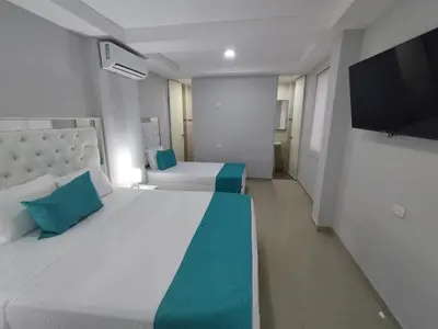a bedroom with two beds and a flat screen tv at Bm-17 Charming Cartagena Lodge with Shared Pool Terrace in Cartagena de Indias