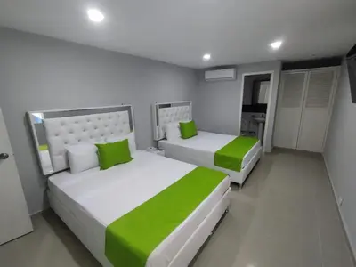 two beds in a room with green and white at Bm-12 room near the sea with air conditioning and WIFI in Cartagena de Indias