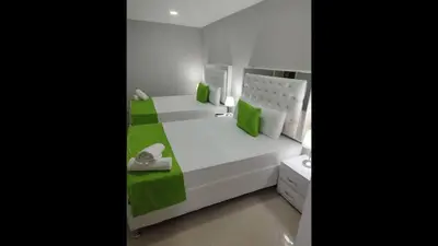 a bedroom with a white bed with green accents at Bm-12 room near the sea with air conditioning and WIFI in Cartagena de Indias