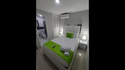 a bedroom with a green and white bed in a room at Bm-13 room near the sea with air conditioning and WIFI in Cartagena de Indias