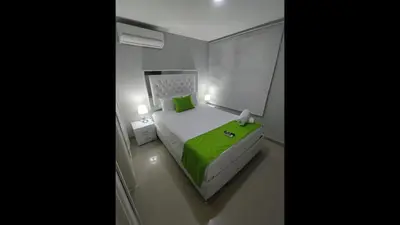 a bedroom with a green bed and a window at Bm-13 room near the sea with air conditioning and WIFI in Cartagena de Indias