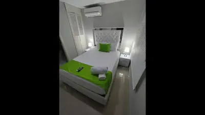 a small bed in a small room with a green blanket at Bm-14G Charming Cartagena Lodge with Shared Pool and Private Terrace in Cartagena de Indias