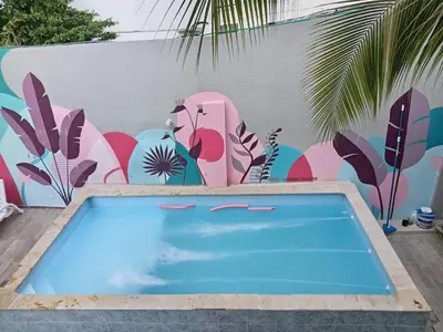 a swimming pool in front of a wall with a mural at Bm-9 room near the sea with air conditioning and WIFI in Cartagena de Indias