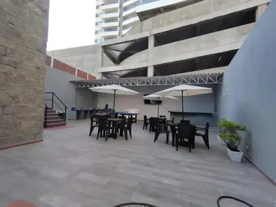 a patio with tables and chairs and umbrellas at Bm-1 room near the sea with air conditioning and WIFI in Cartagena de Indias