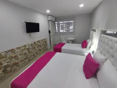 a bedroom with two beds and a flat screen tv at Bm-1 room near the sea with air conditioning and WIFI in Cartagena de Indias