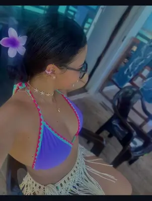 a woman in a purple dress with a flower in her hair at Roma beach in Cartagena de Indias