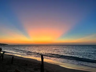 a rainbow in the sky over the beach at Roma beach in Cartagena de Indias